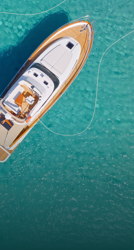 birds-eye view of beautiful turquoise water, floating on top of which is an impressive 8–10-person boat