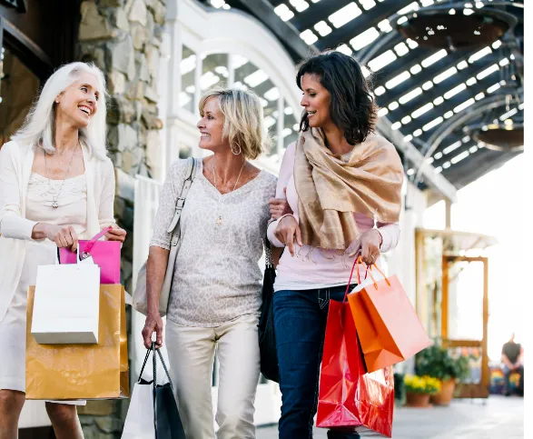 women holding shopping bags shopping in an outdoor center