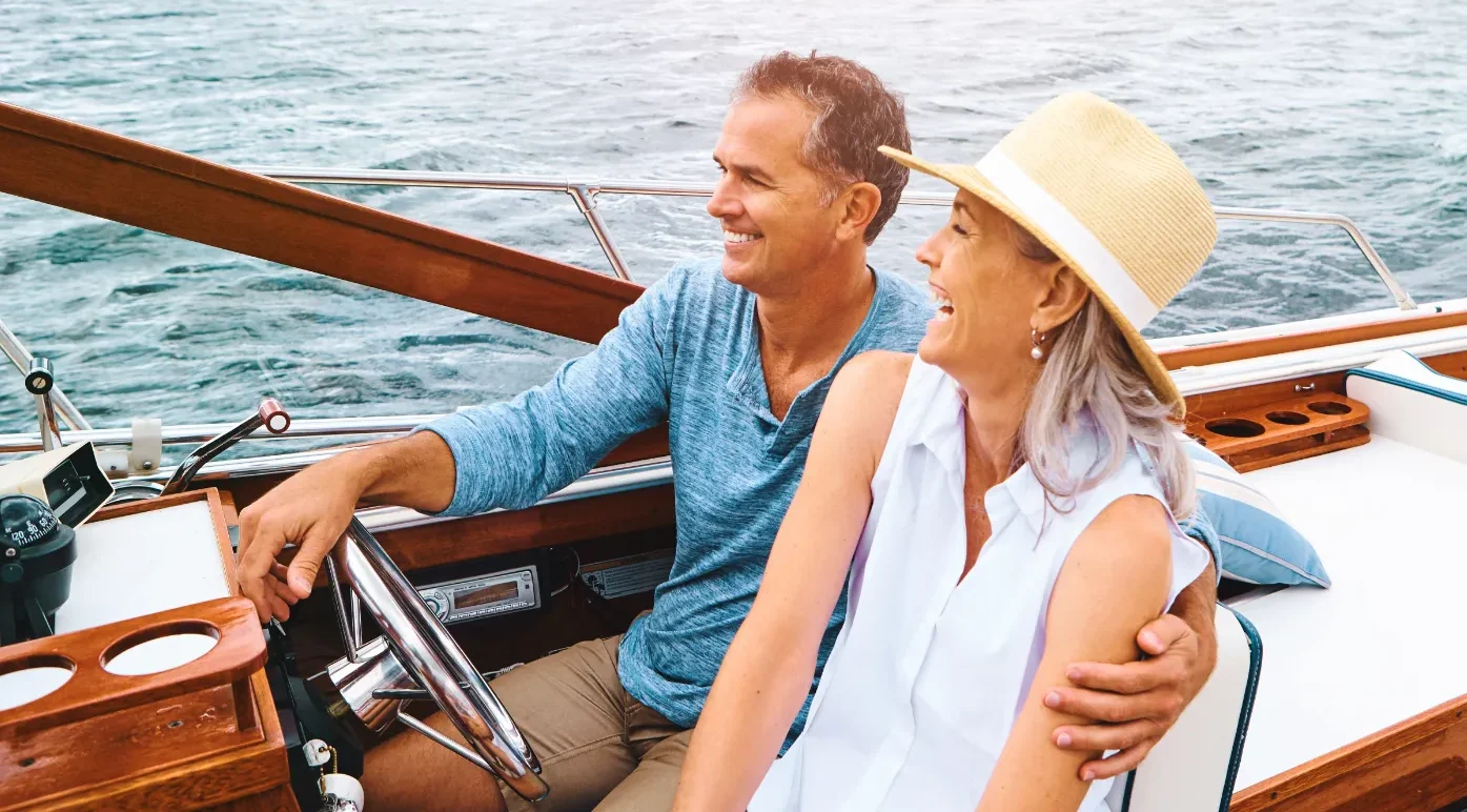 Man and woman laughing in a small luxury boat on the water