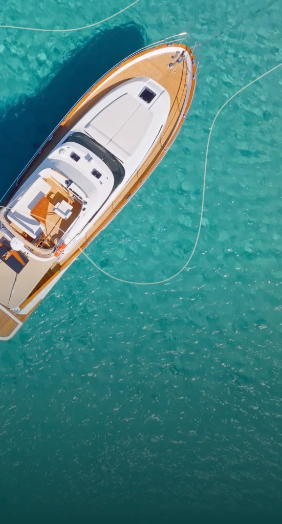 birds-eye view of beautiful turquoise water, floating on top of which is an impressive 8–10-person boat